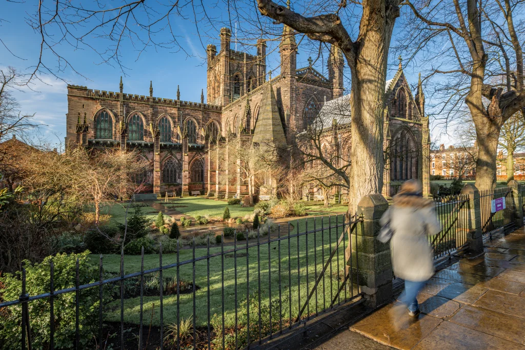 People walking on Chesters Roman Walls with the Chester Cathedral in the background