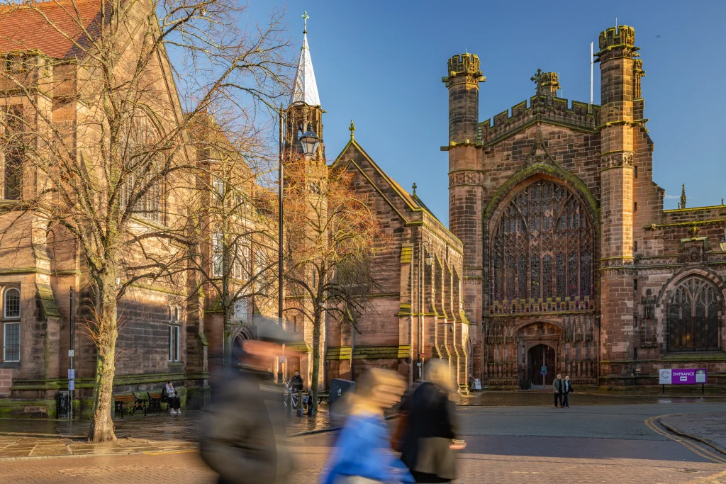 People walking down the street, blue jumper, Chester Cathedral in background