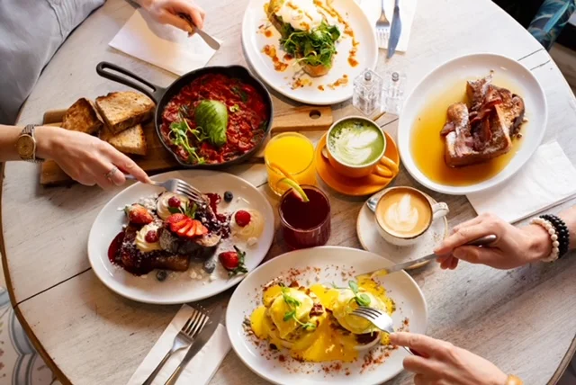 People eating from a table full of food