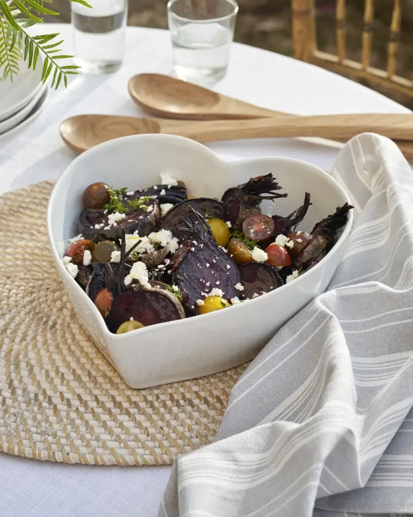 a heart shaped bowl with mixed vegetable inside