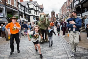 children running away from dinosaur in chester city centre