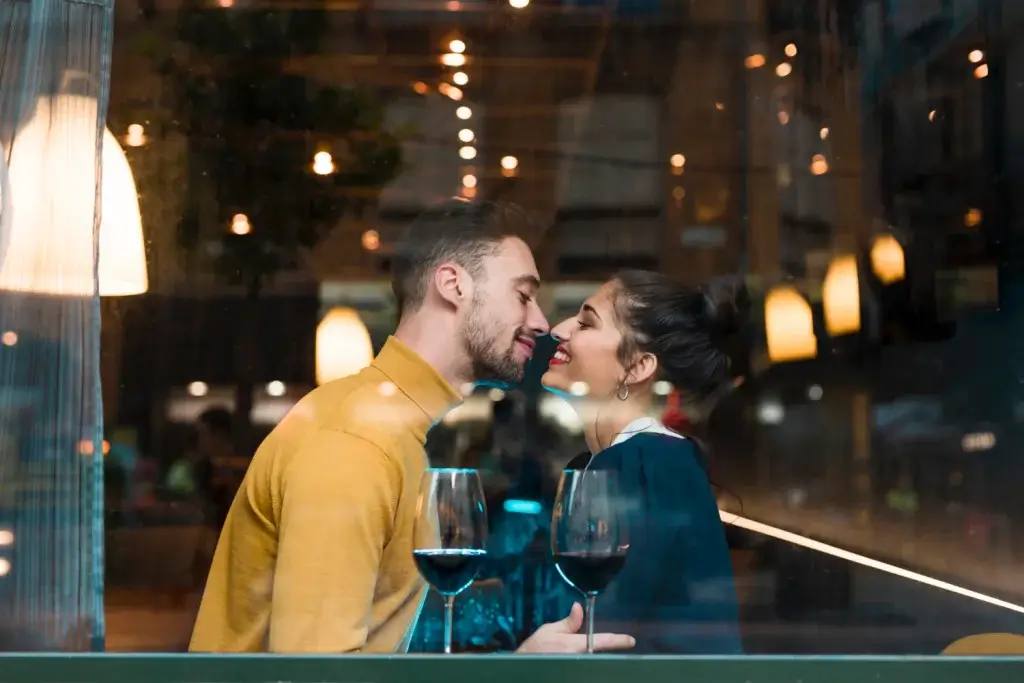 Happy man and woman near glasses of wine in restaurant