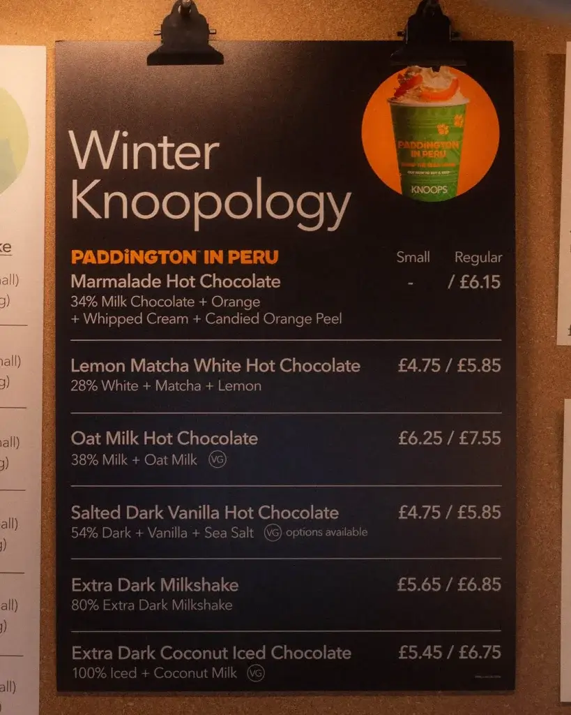 A menu board featuring winter hot chocolate options, including flavors, ingredients, and prices for small and regular sizes.