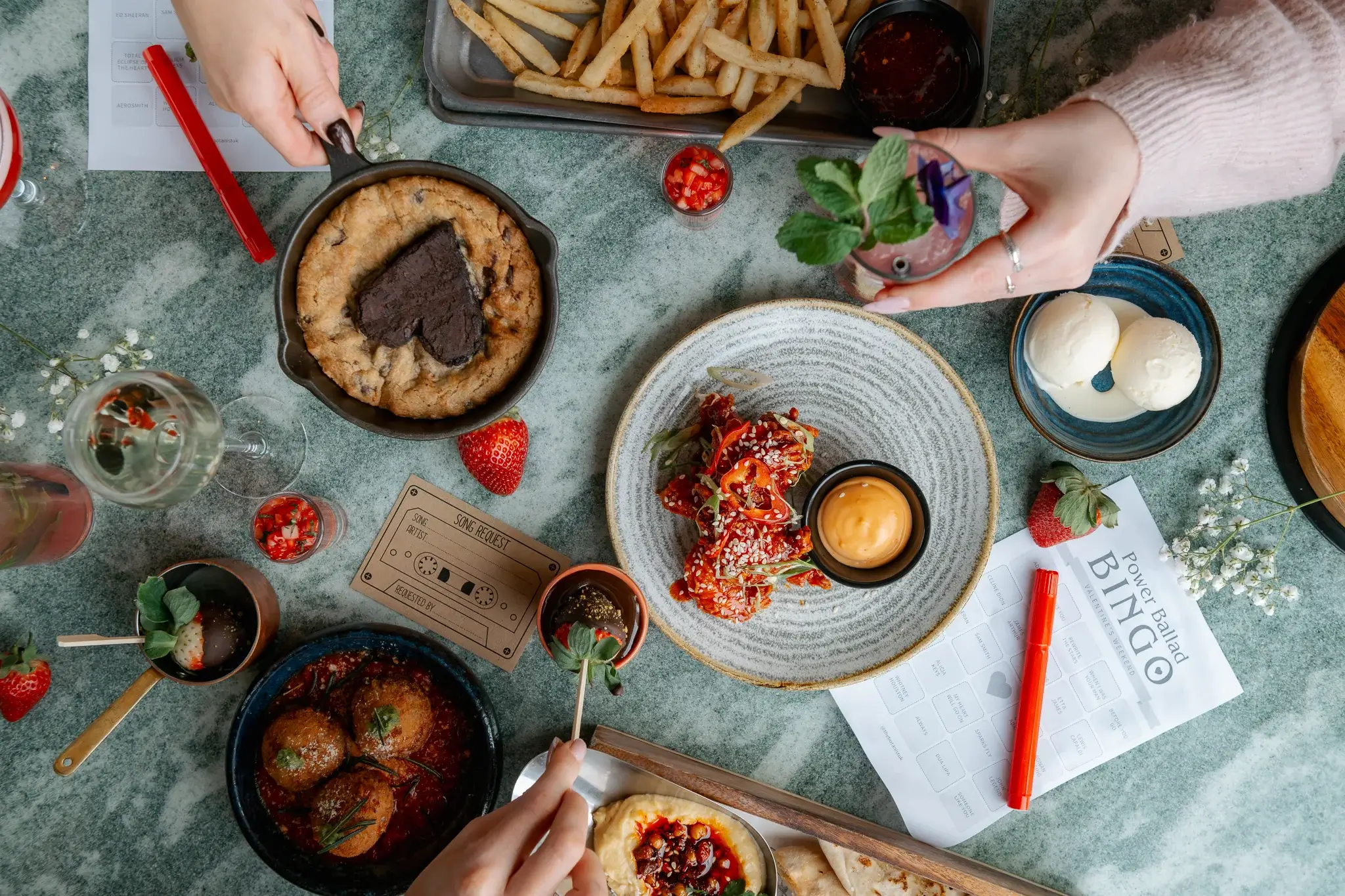 A table full of Valentines Food such as cookie dough, strawberries and chocolate